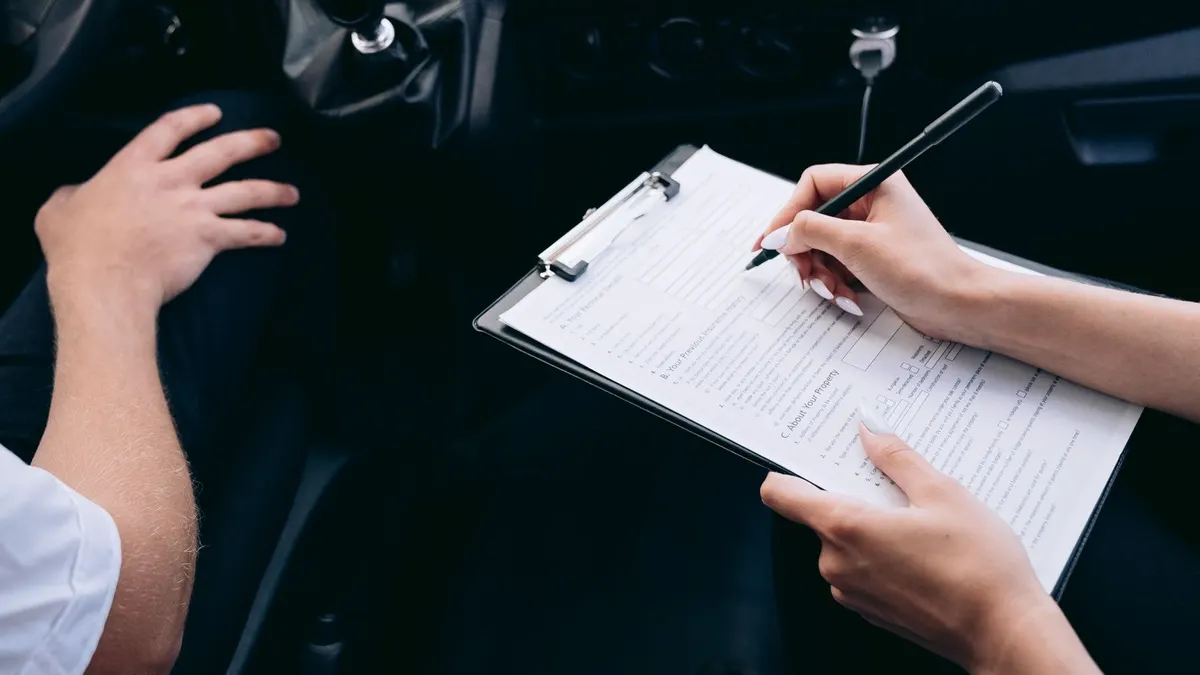 Un vendeur remet le certificat de situation administrative à un acheteur devant une voiture.